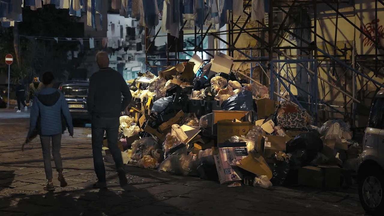 Night walk past piled waste in Naples Italy