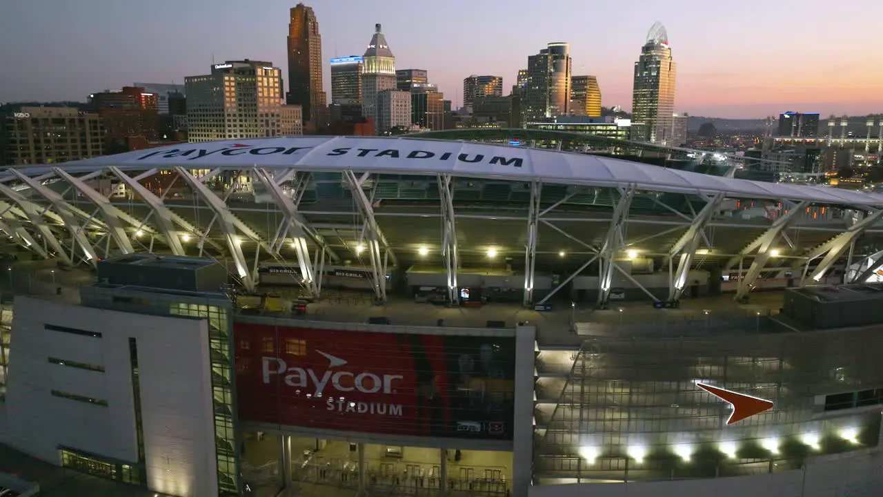 Aerial view over the Paycor Stadium towards the Cincinnati skyline sunset in Ohio USA rising drone shot