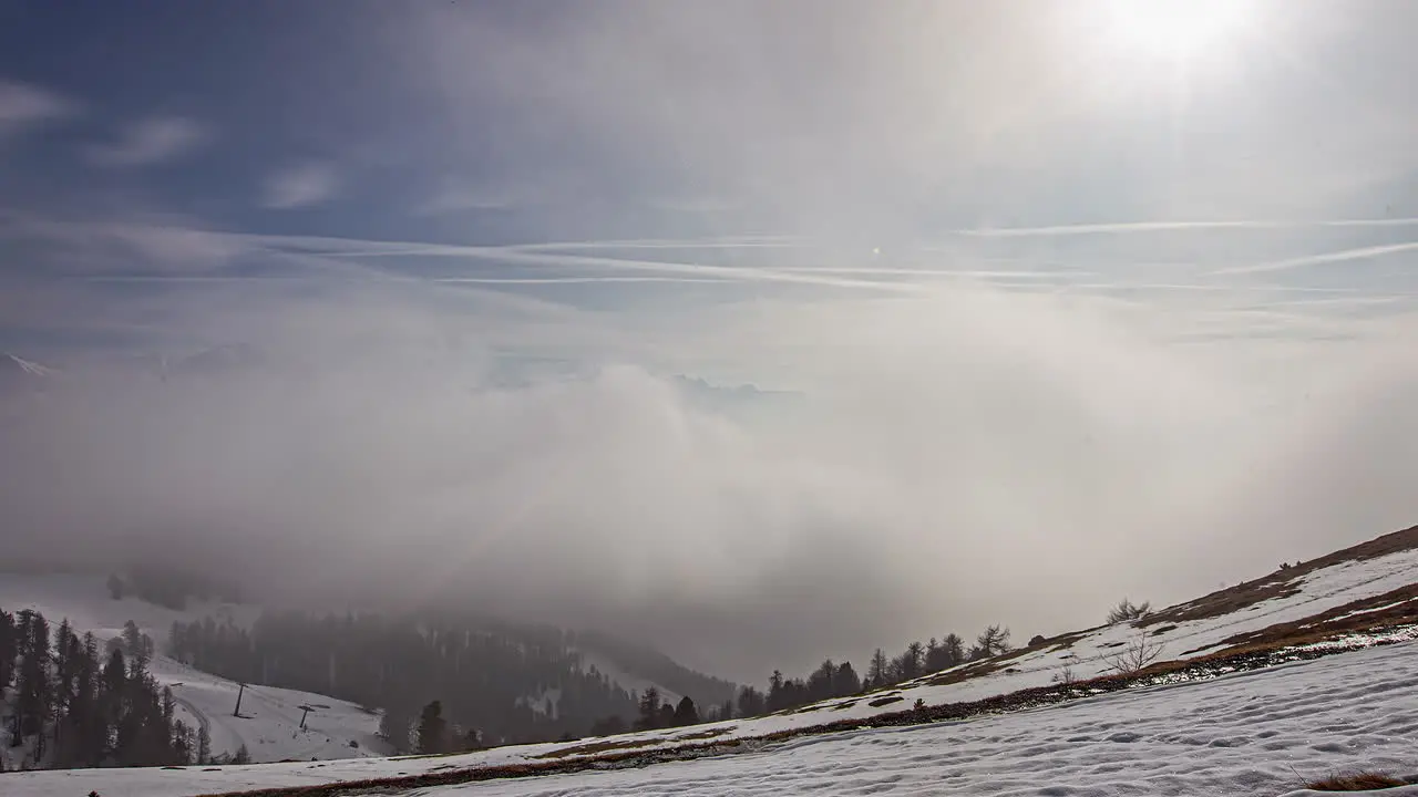 Snowy billowing clouds and fog over a winter mountain landscape dynamic time lapse