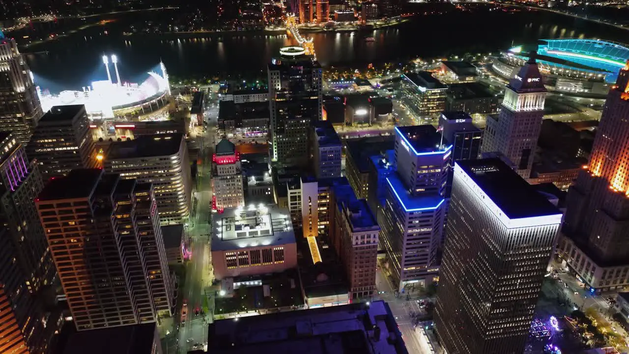 Aerial view overlooking the lit up night cityscape of downtown Cincinnati during Blink the festival of lights and arts in Ohio USA tilt drone shot