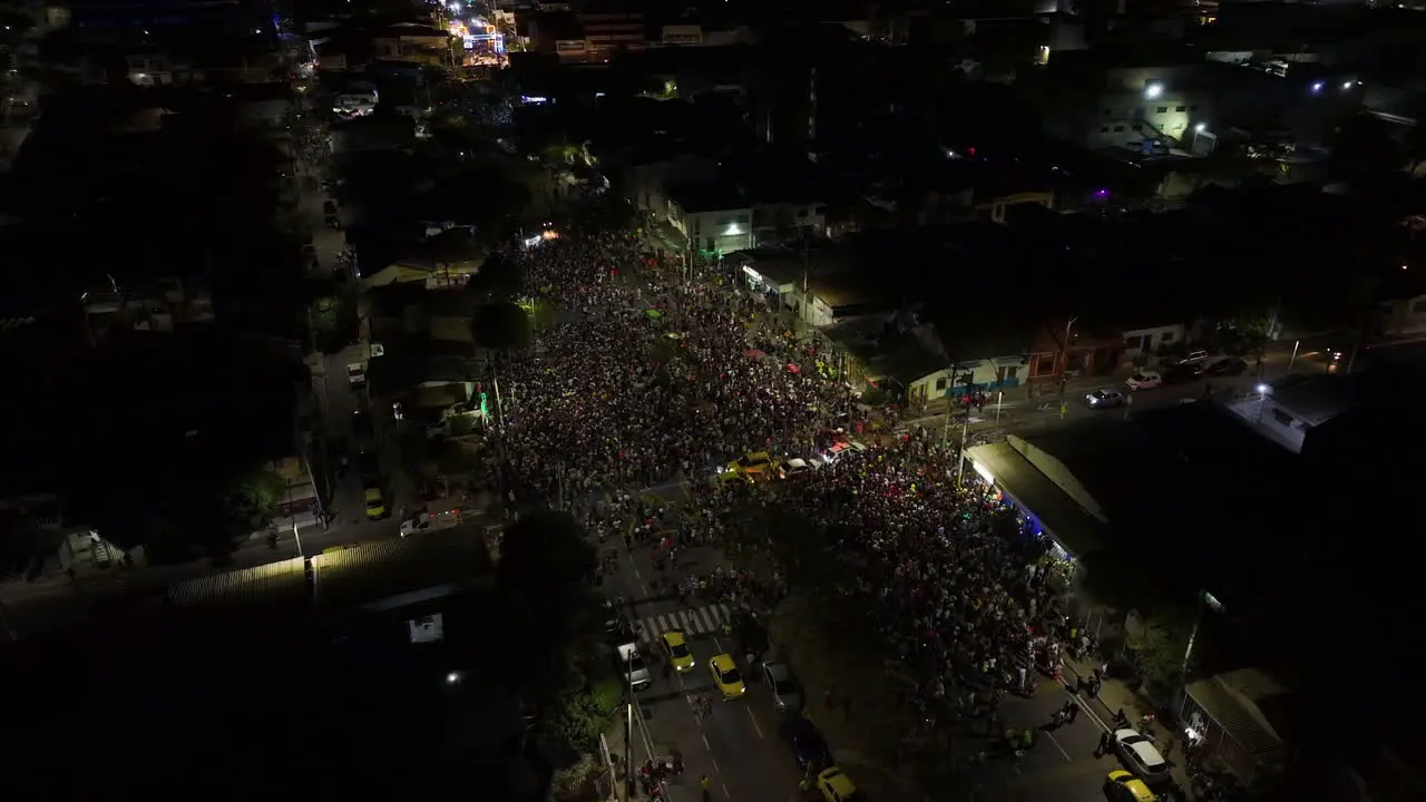 Aerial view around a street full of people celebrating the Carnival of Barranquilla night in Colombia