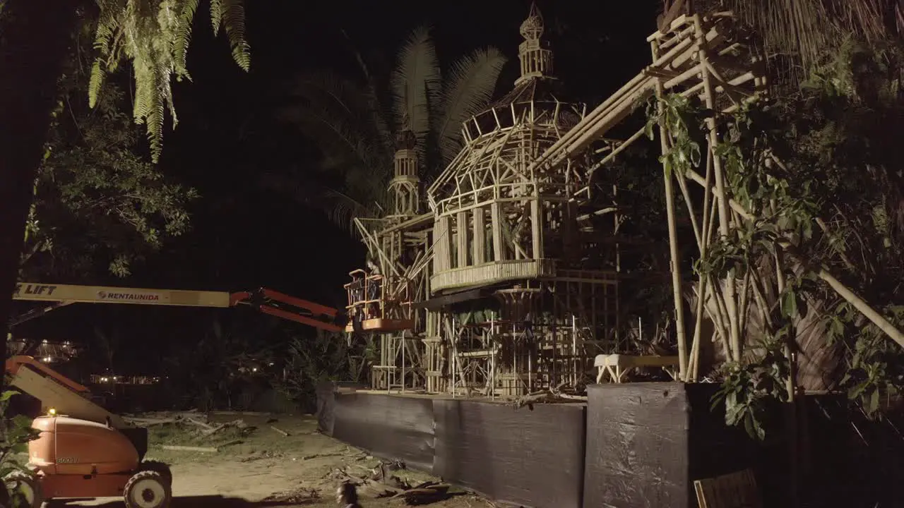 Performance stage temple of the Envision Festival being set up at night with a crane Aerial closing in shot