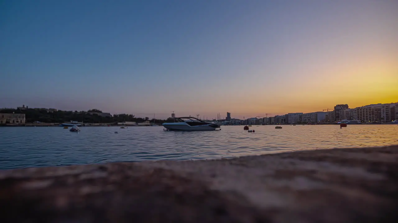 Boat anchored in the bay at sunset offshore from Sliema Malta time lapse