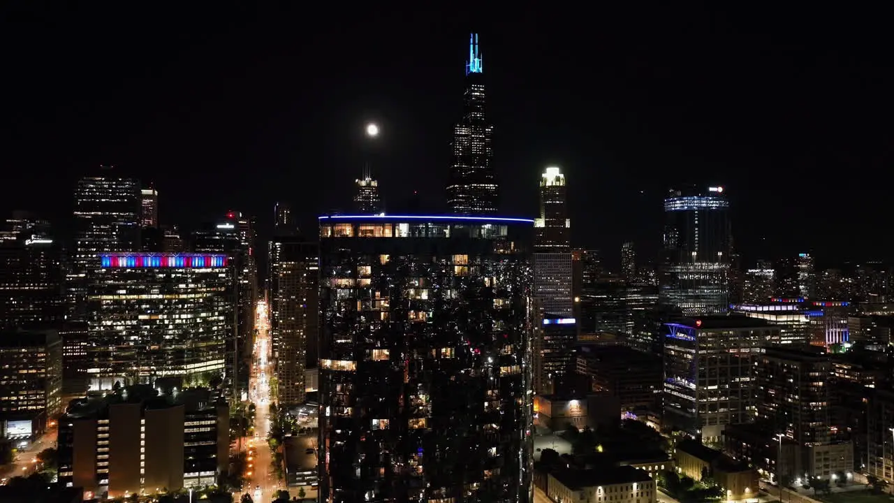 Aerial view approaching a deluxe condo with full moon Chicago skyline background