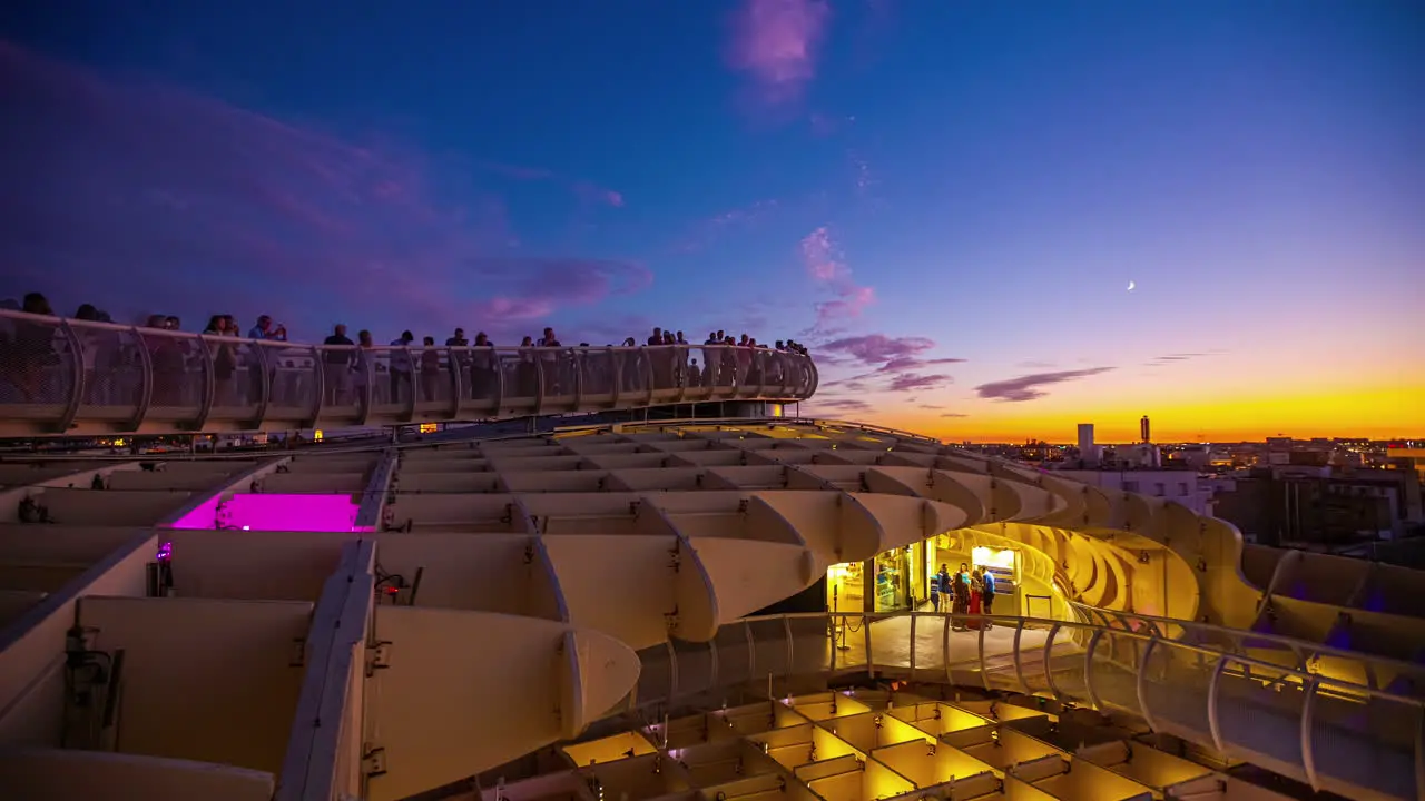 Setas de Sevilla at twilight with a crescent moon over the walkway time lapse