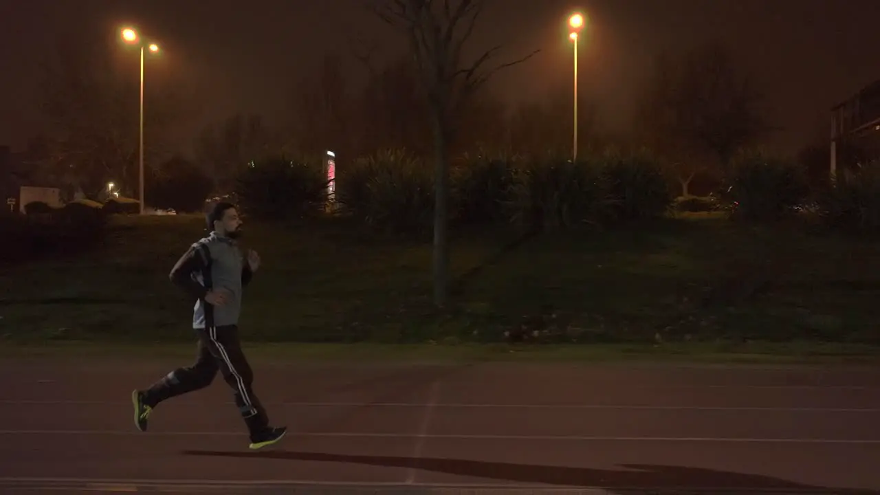 Tracking Shot of sportive person jogging near busy street In Spain