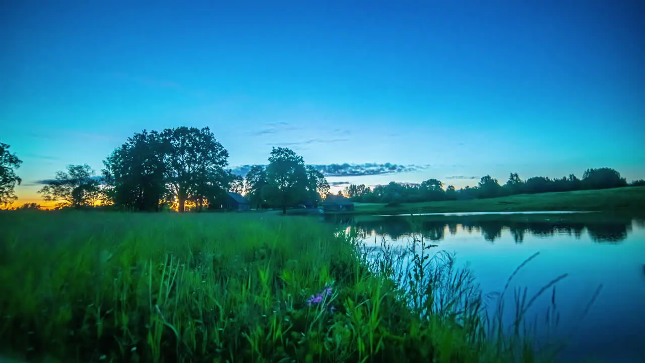 Night to sunrise to all day time lapse of a cabin by a lake