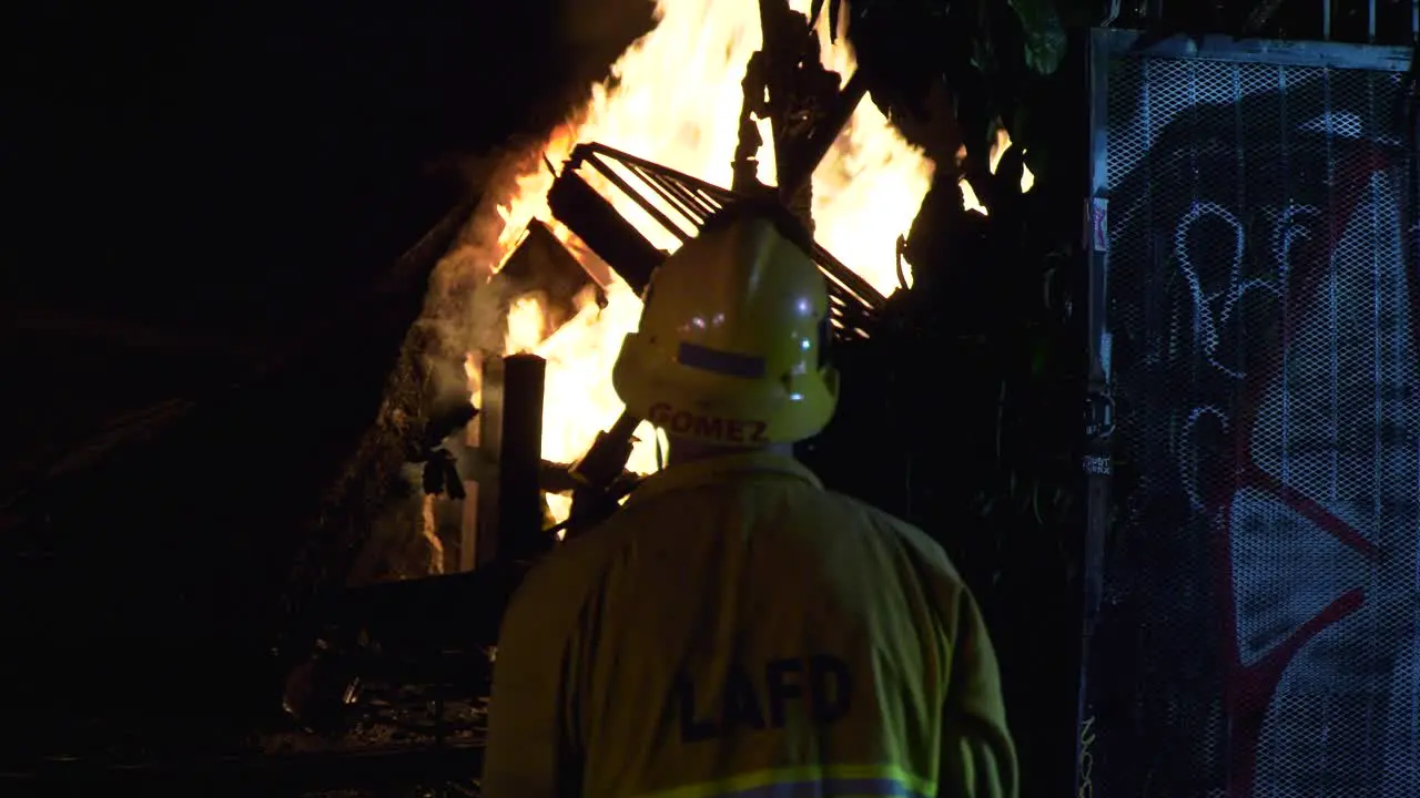 LAPD Firefighter watching a house on fire late night in Los Angeles USA