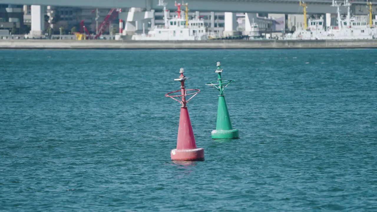 A slow motion shot of a red and a green buoys floating in Tokyo bay Japan