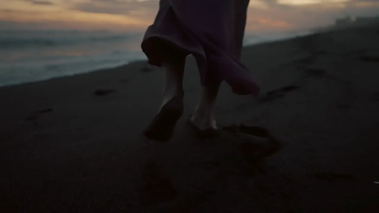 Barefooted Woman Walking On The Beach Leaving Footprints On The Sand