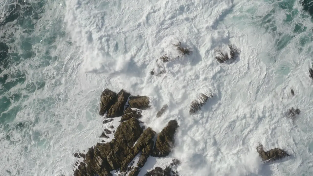 4K cinematic drone overhead shot of massive waves breaking on rocks at Point Lobos Marine Reserve California