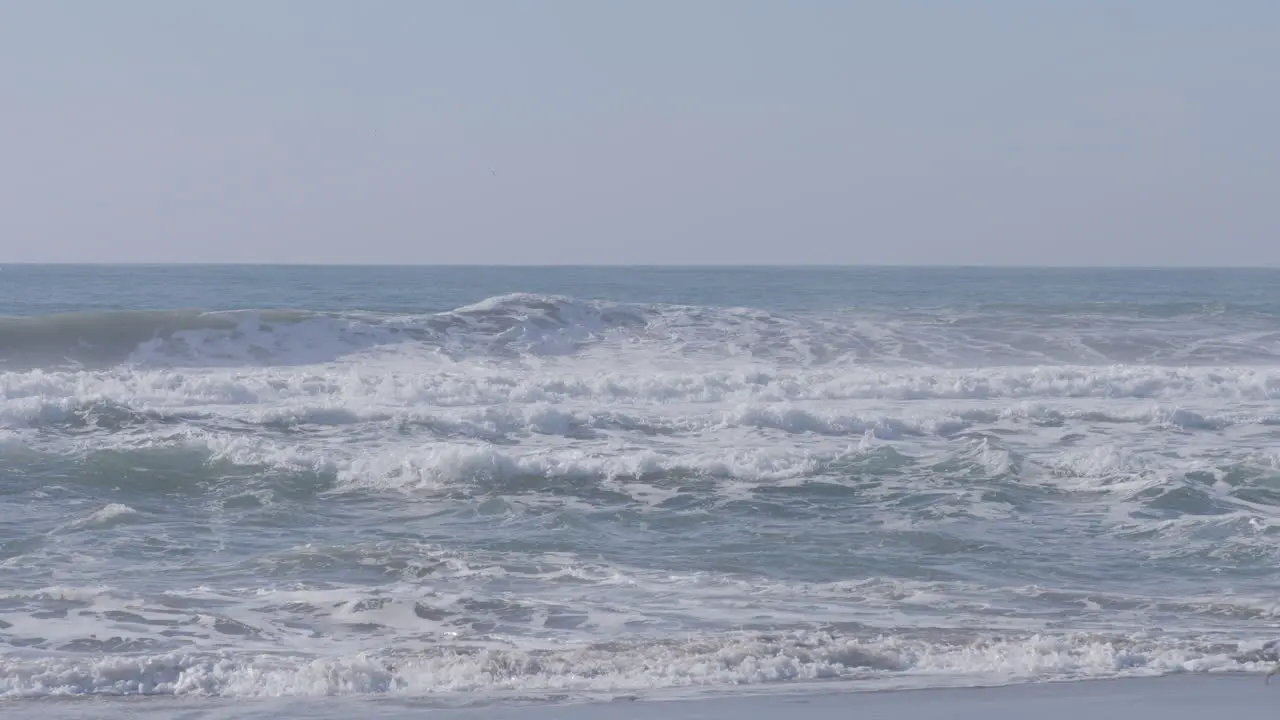 Slow motion shot of waves crashing along the beach of Marina State Beach Monterey Bay California