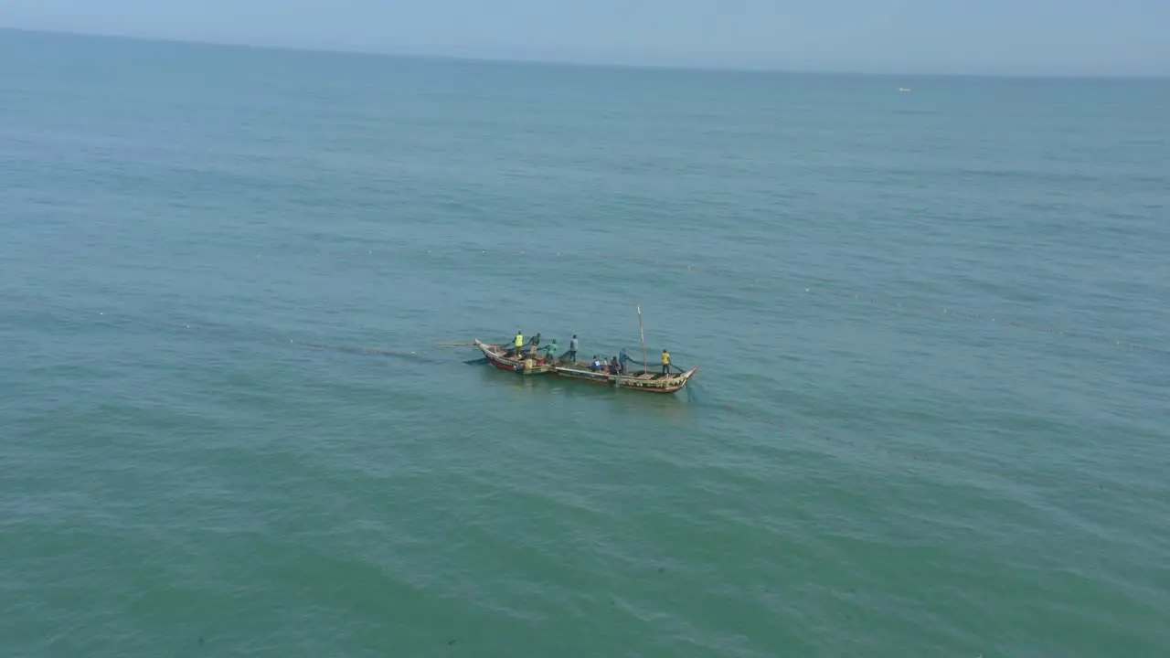 Fishermen at sea casting net in Ghana