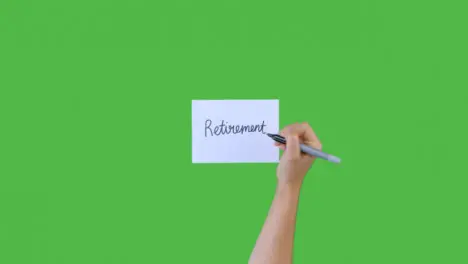 Woman Writing Retirement In Cursive on Paper with Green Screen