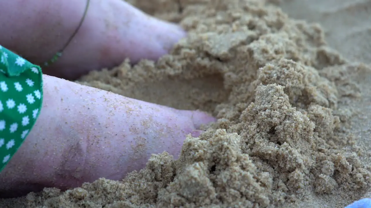 Girl putting feet in sand