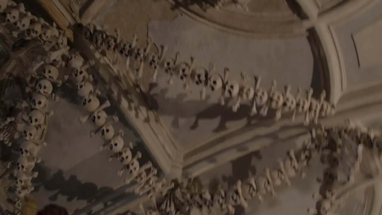 Frightening roof beams chandeliers made from human remains skulls bones hanging from ceiling in Roman Catholic chapel Sedlec Ossuary Czech republic