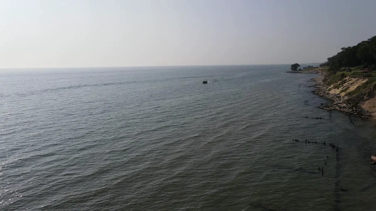 Drone approaching a traveling pontoon boat on lake Michigan