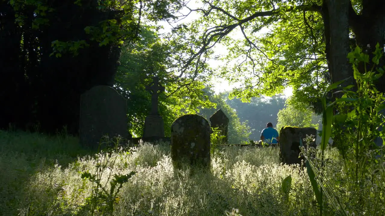 Rear Of A Man Sitting At The Abandoned Celtic Graveyard In County Wexford Ireland