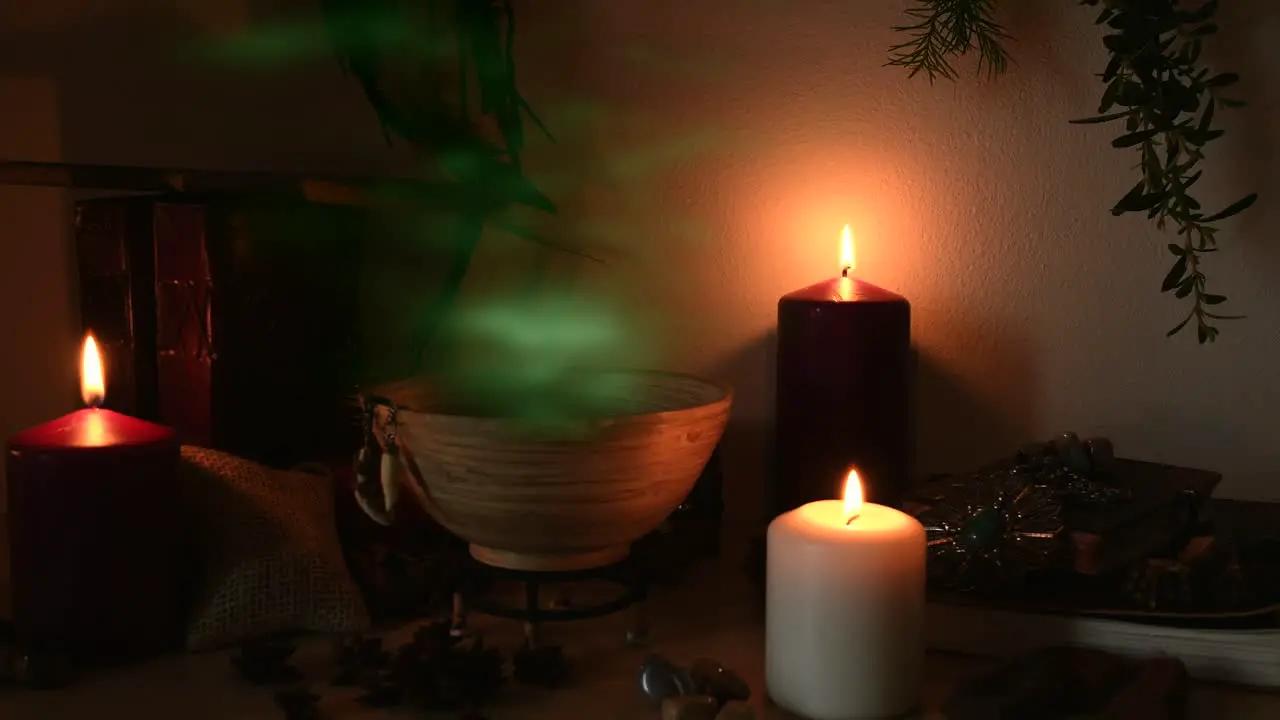 Detail of a potion making witch room with green steam coming out from a wooden bowl animal teeth hanging from it candles with flickering flames old books glasses and herbs in the background