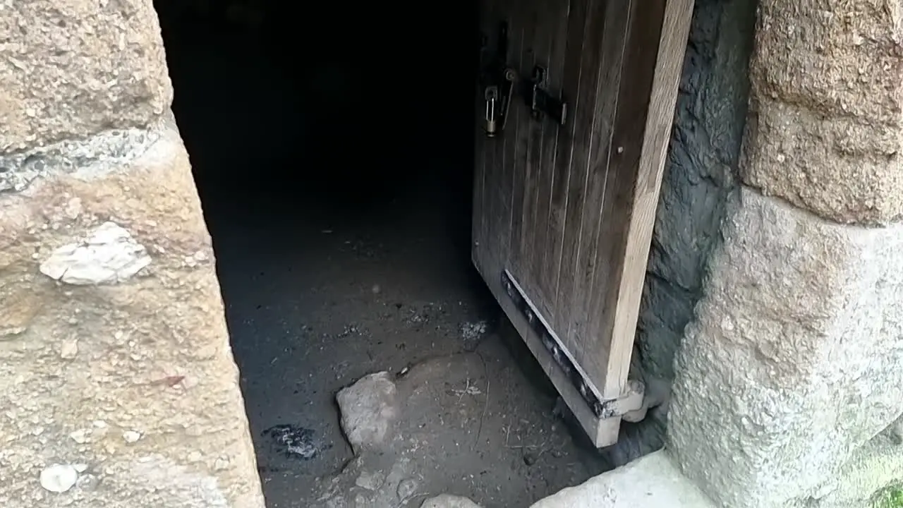 Paranormal ghostly orb light floating across old medieval wooden doorway entrance