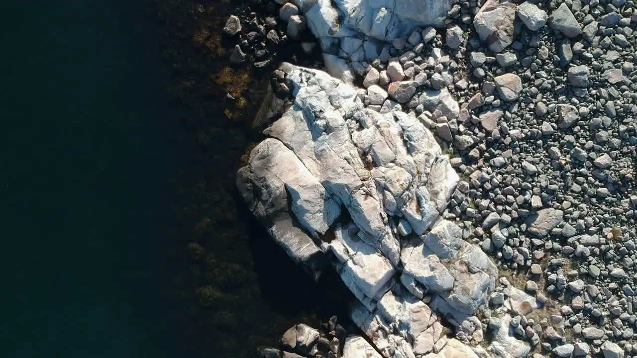 Aerial drone dolly overhead view shot of a rocky ocean coast line on the west coast of Sweden in Bohuslän outside of Gothenburg