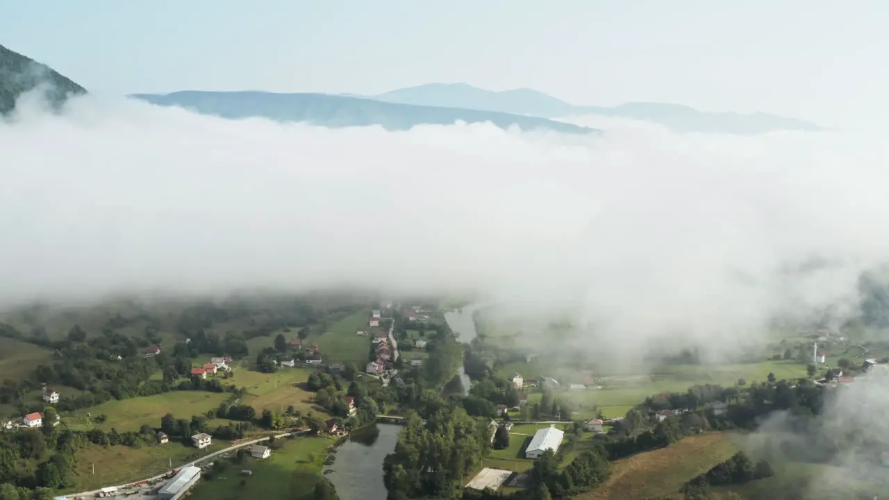 Beautiful valley with houses under clouds and mountain in peaceful setting