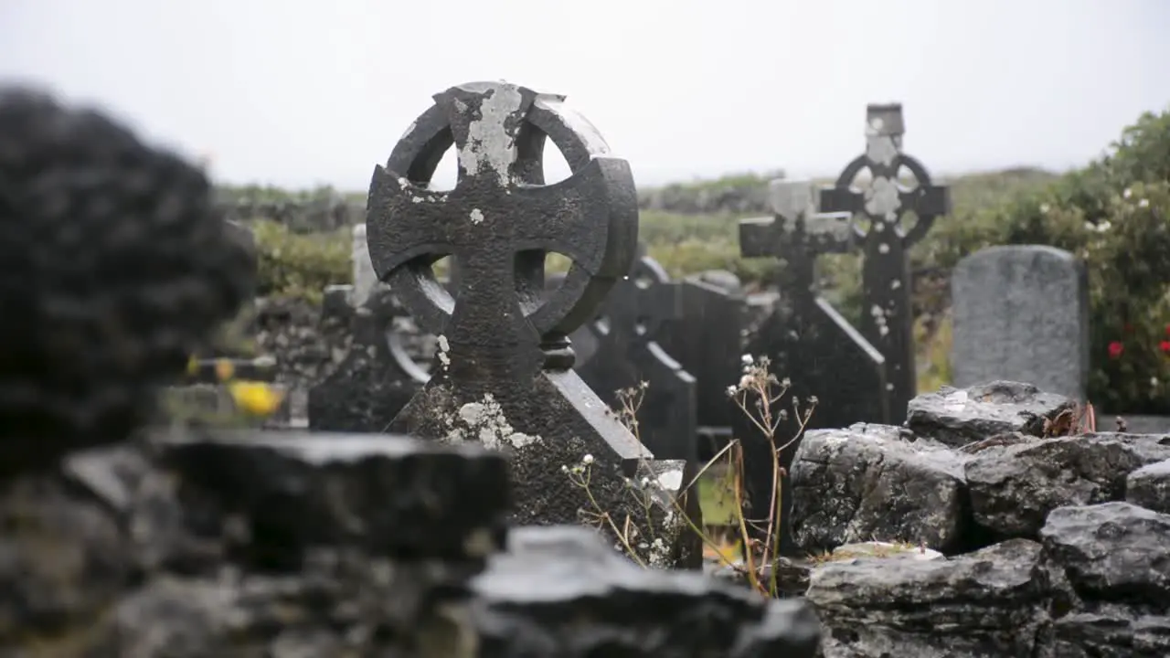 Old Tombstones in Shape of Crosses in the Pouring Rain in a Cemetery on a Cloudy Day