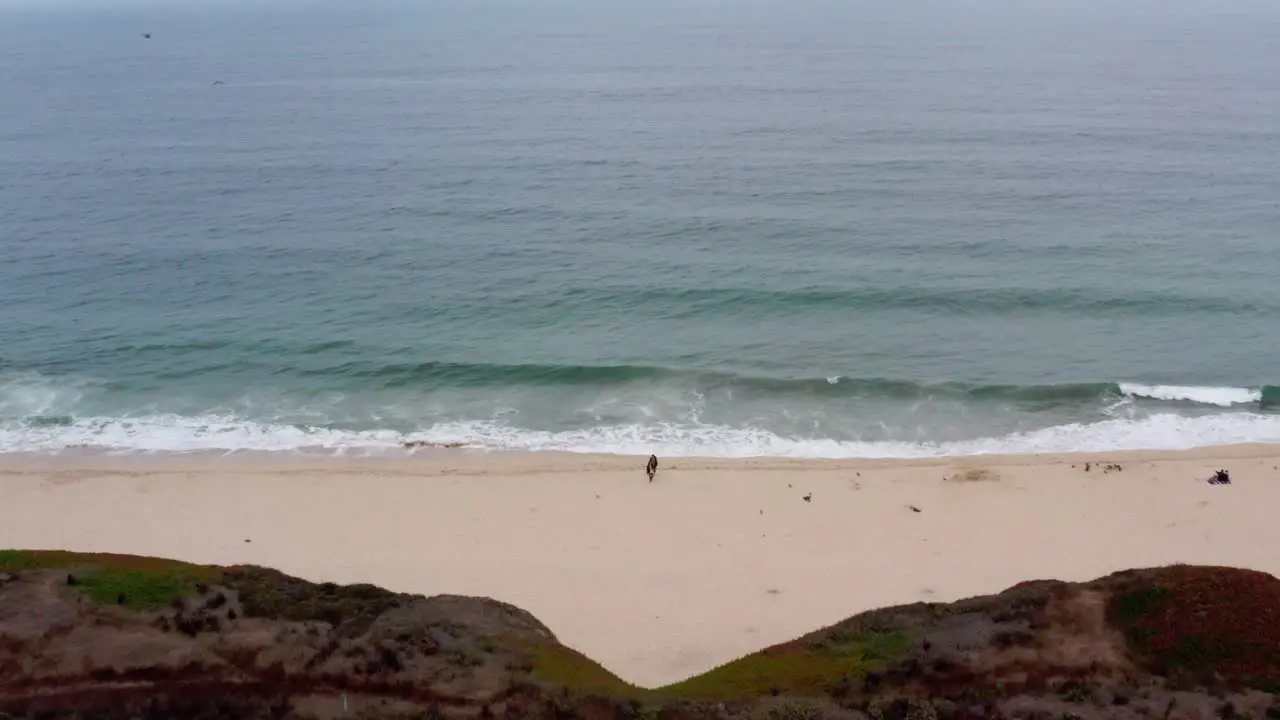 AERIAL drone half moon bay beach cliffs and shore flying away view