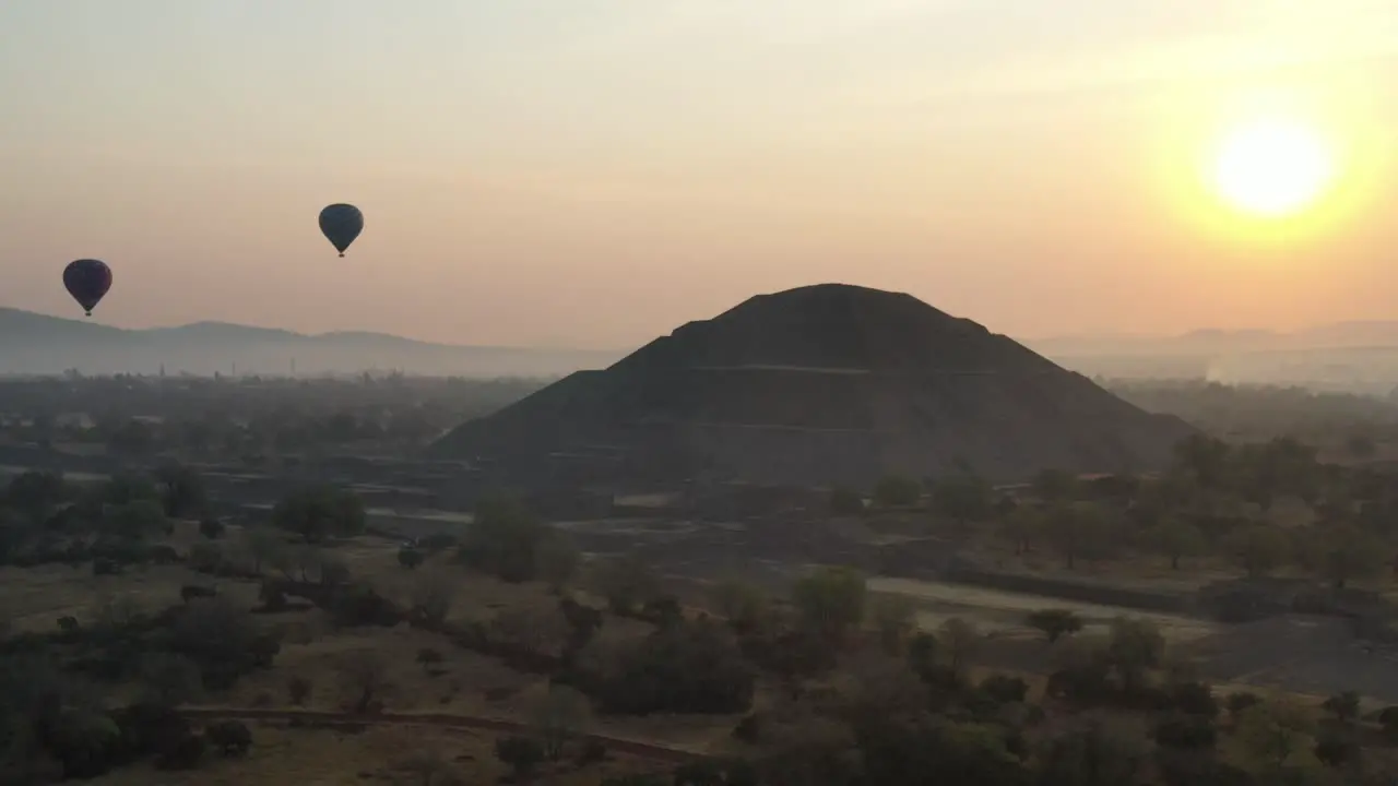 Aerial view of hot air baloon flying over Teotihuacan Mexico during foggy sunrise 4K