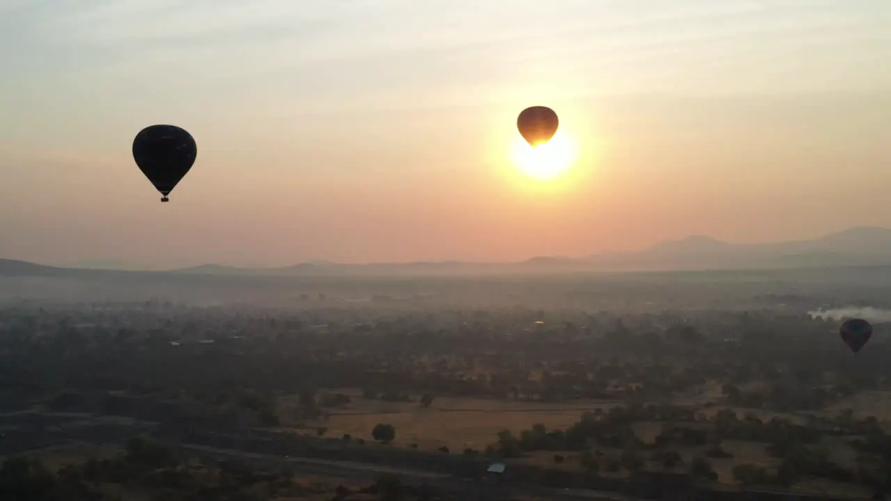 Aerial view of hot air baloon flying over in Teotihuacan Mexico during foggy sunrise 4