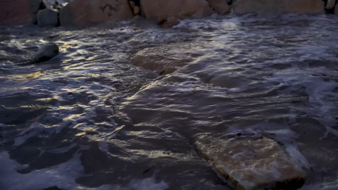 Waves crashing over rocks at night