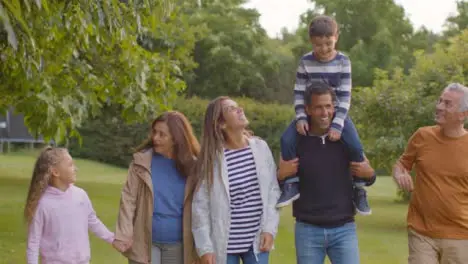 Tracking Shot of Family Walking Together Through Gardens