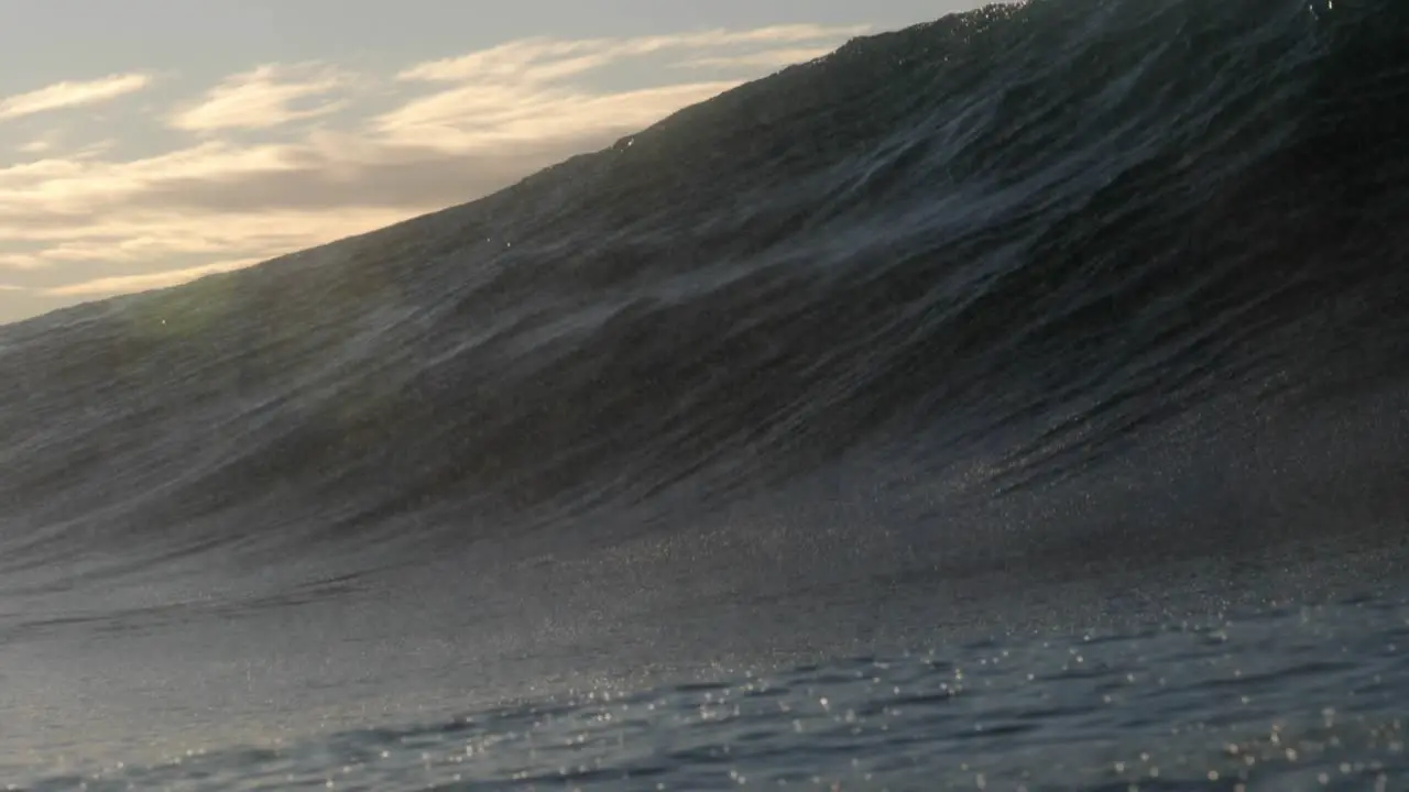 A heavy short wave breaks over a shallow rock ledge as the sun rises in the background on the east coast of Australia