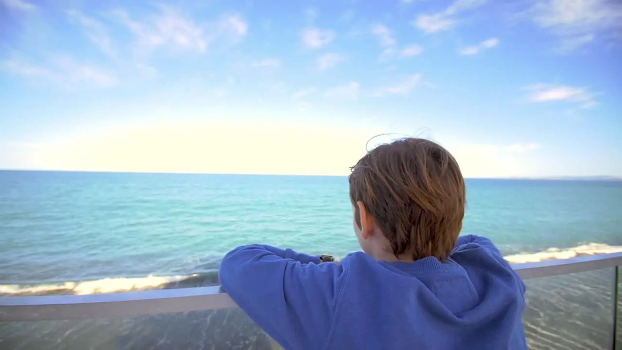 Young Boy Looking Out Over Ocean