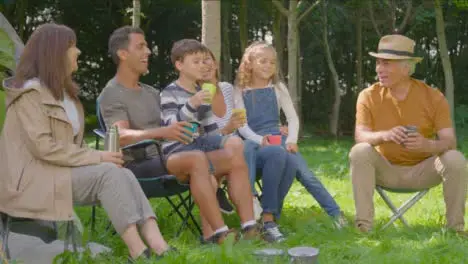 Wide Shot of Family Sitting by Tent On Camping Holiday