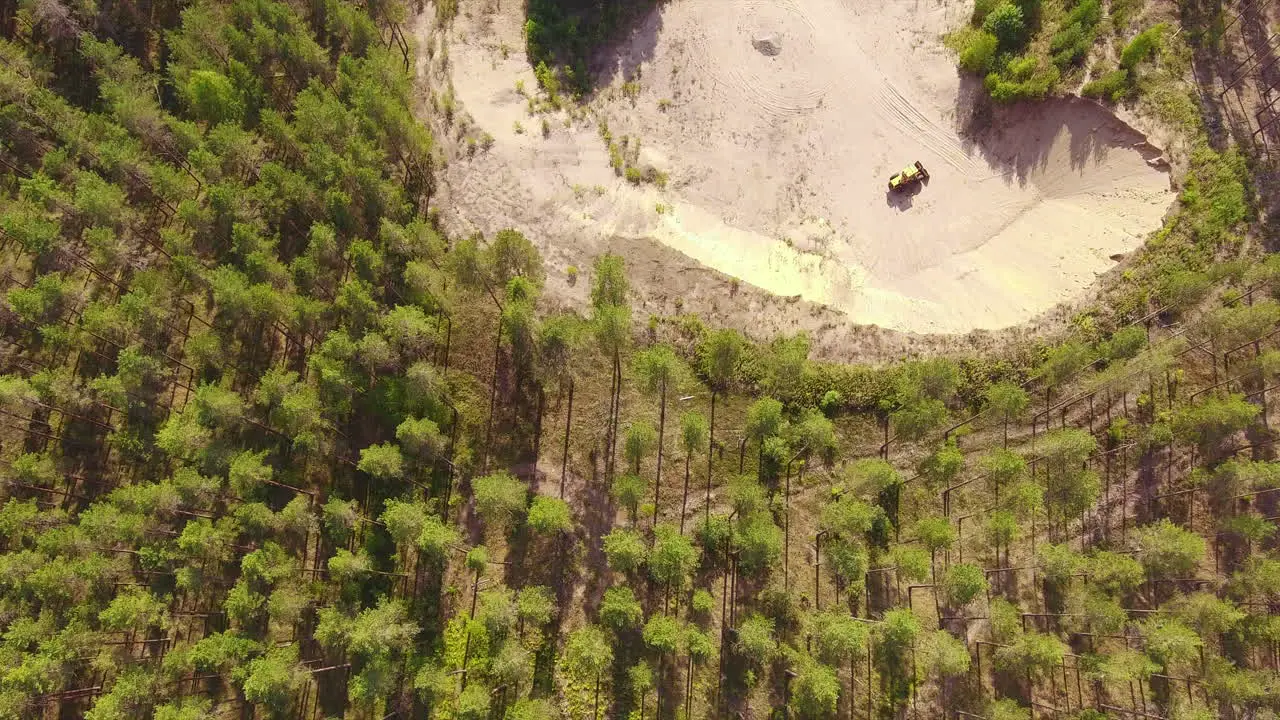 Drone video of an old bulldozer in a gravel pit beautiful coniferous forest surroundings