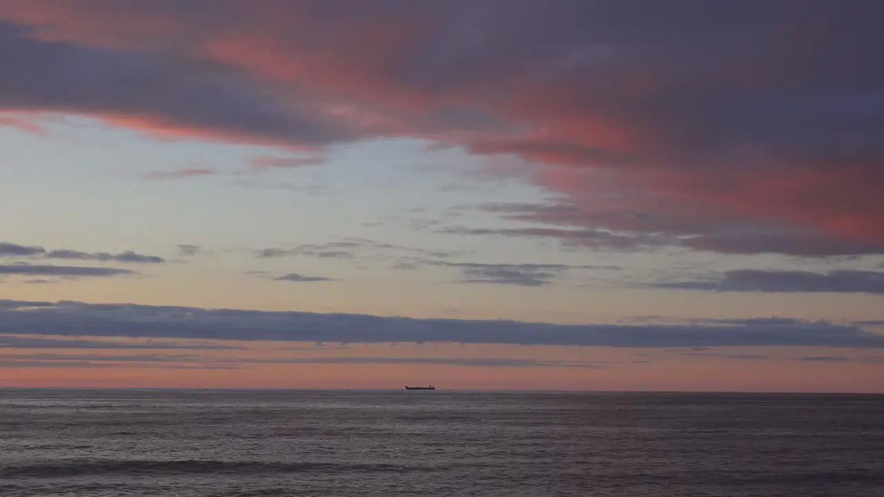 A very distant cargo ship on the horizon at sunset