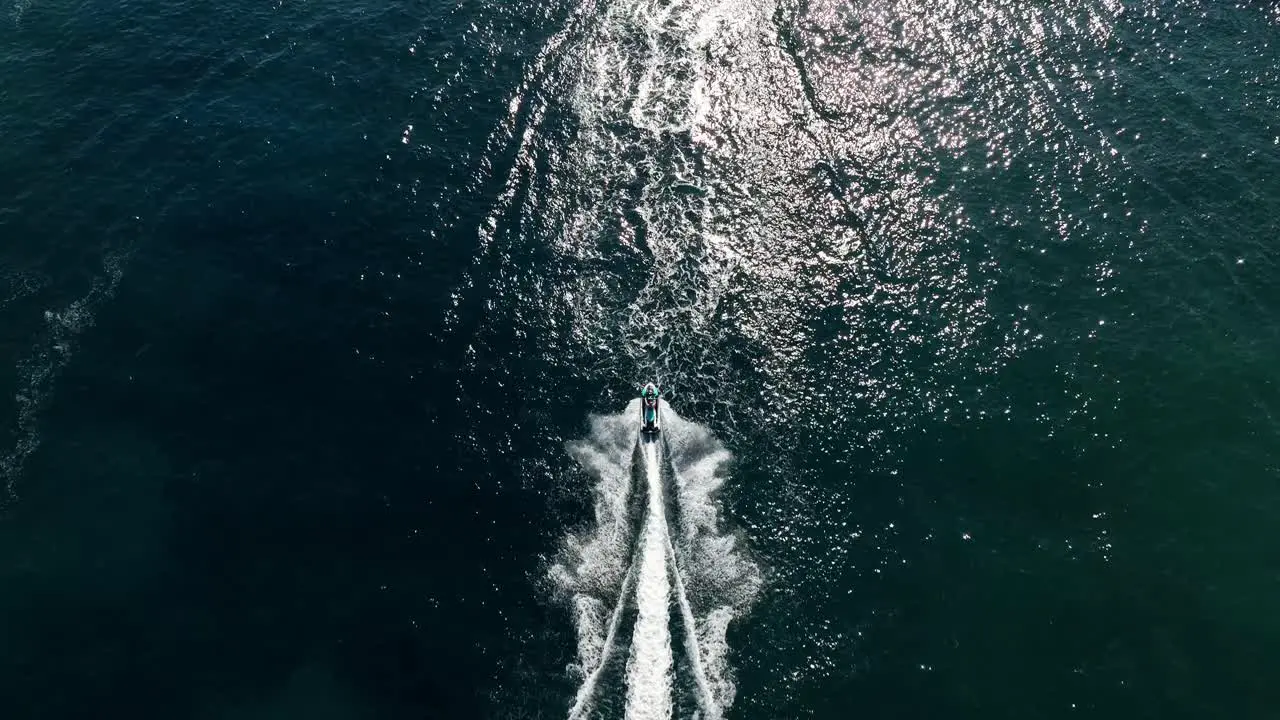 Aerial view taken with drone following a jetski on water in slowmotion