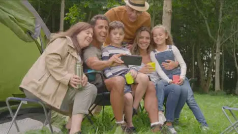 Wide Shot of Family Taking Selfie On Camping Trip 