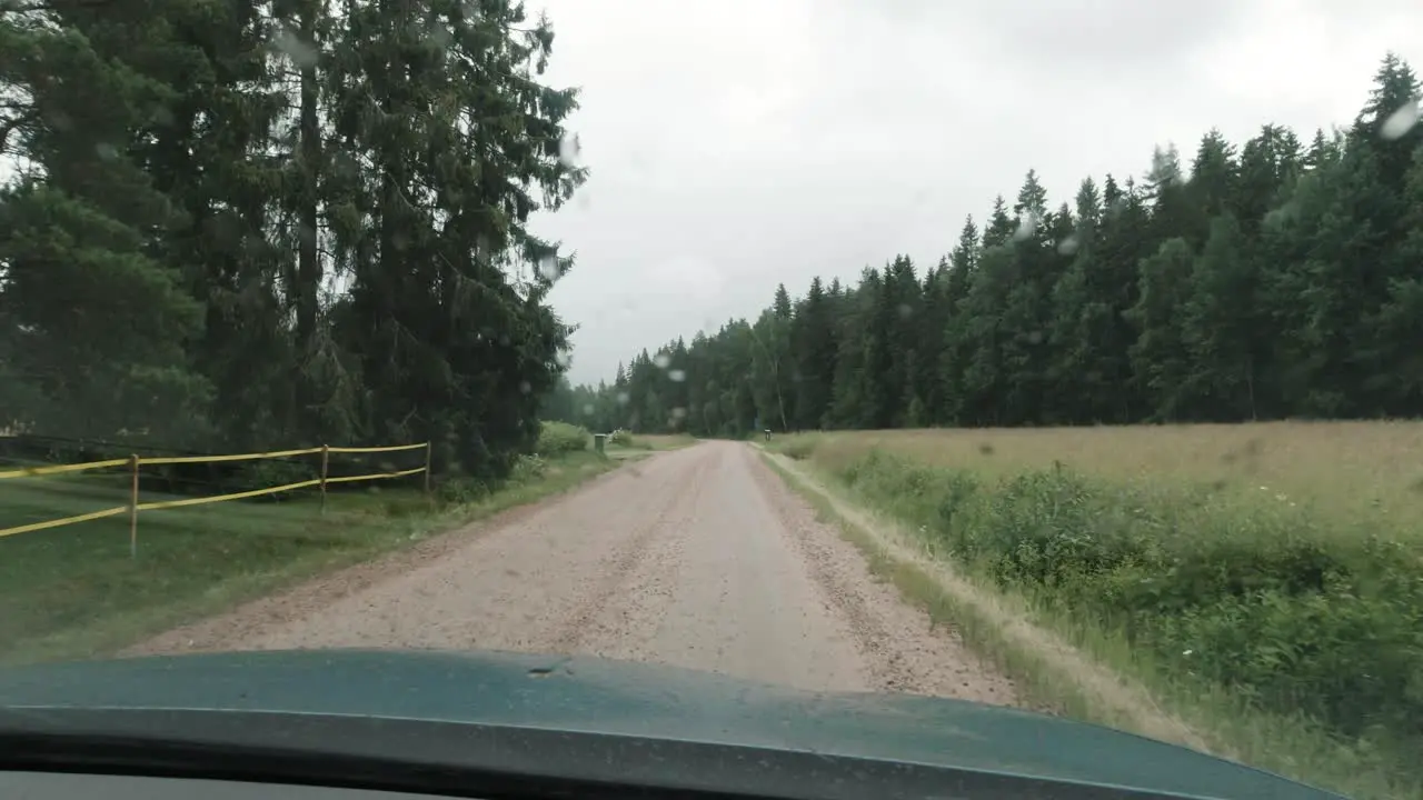 Driving a car in the rain on a dirt road