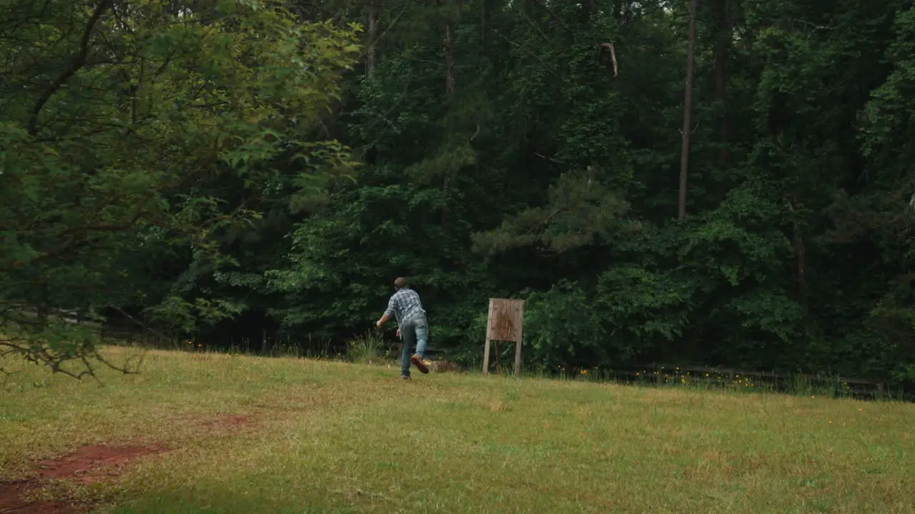 Slow motion of modern sport of axe throwing involves a competitor throwing an axe at a target