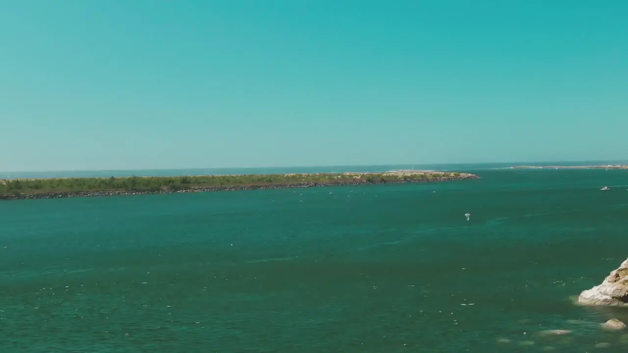 4k Aerial Birds flying above water on Oregon coast with rocks in foreground