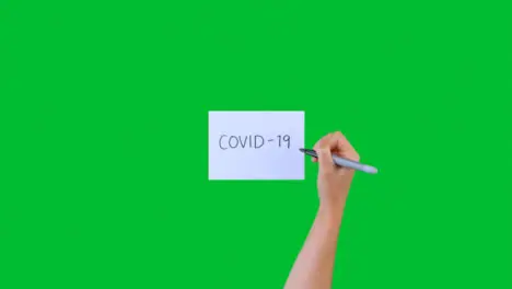 Woman Writing Covid-19 on Paper with Green Screen