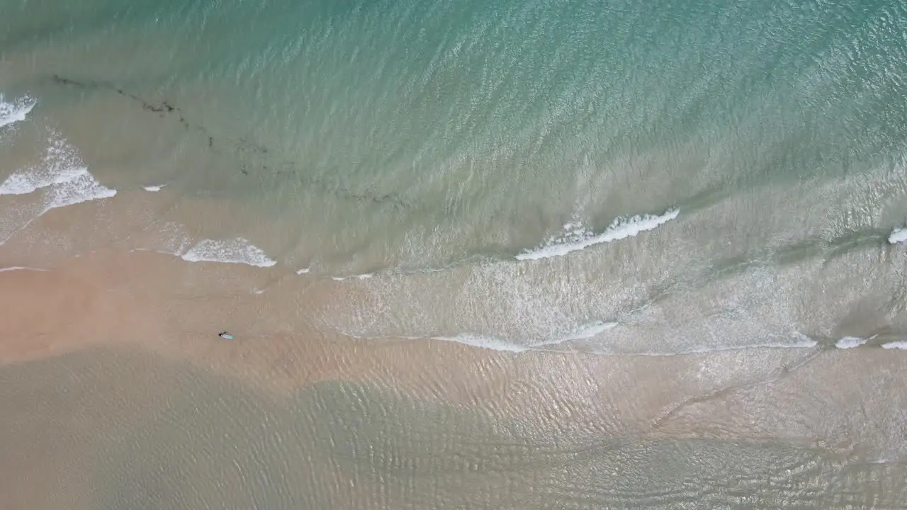 aerial drone shot of a surfer dad teaching his son to surf in the middle of the ocean in Fuerteventura Canary Islands