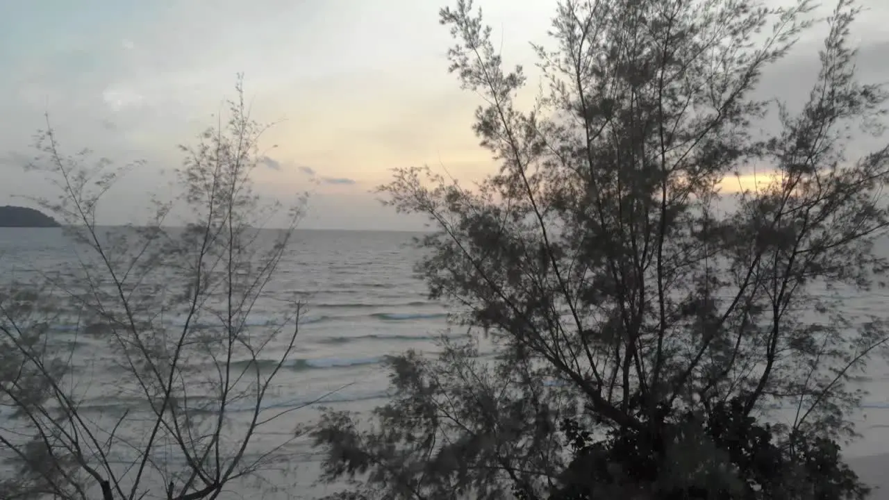 Cinematic aerial shot of big waves crashing onto island coastline in cambodia asia at sunset with deep glow from sun over the ocean water-2