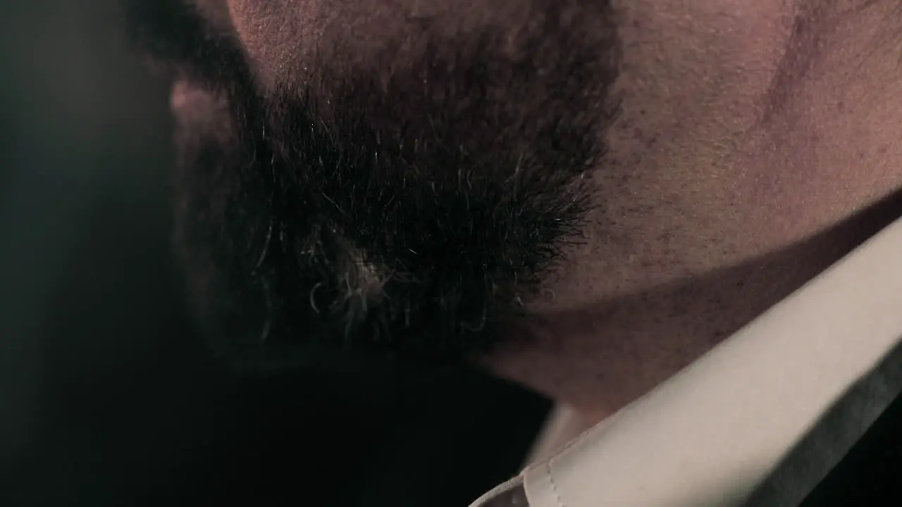 Side view close up of caucasian business man in suit's thick black beard