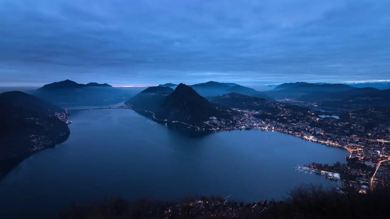 Evening Timelapse of the city and lake Lugano from Monte Bre Switzerland as the city lights up