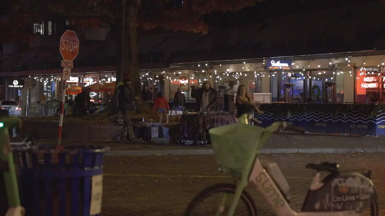 DJ performing on street corner while someone dances