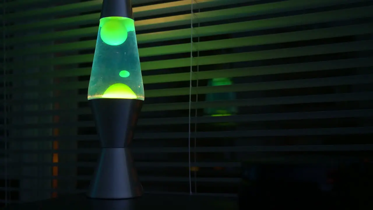 Green lava lamp time lapse in a dark room-office near a window