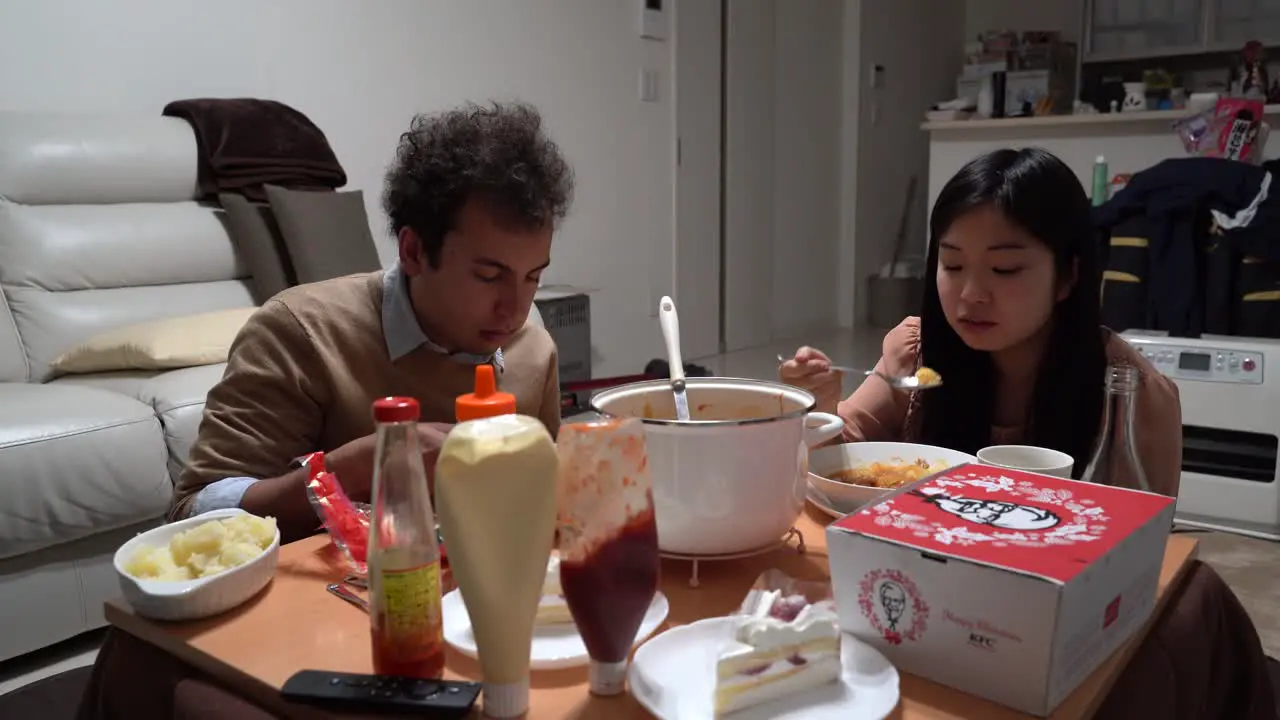 Couple having traditional Japanese Christmas dinner with KFC home party